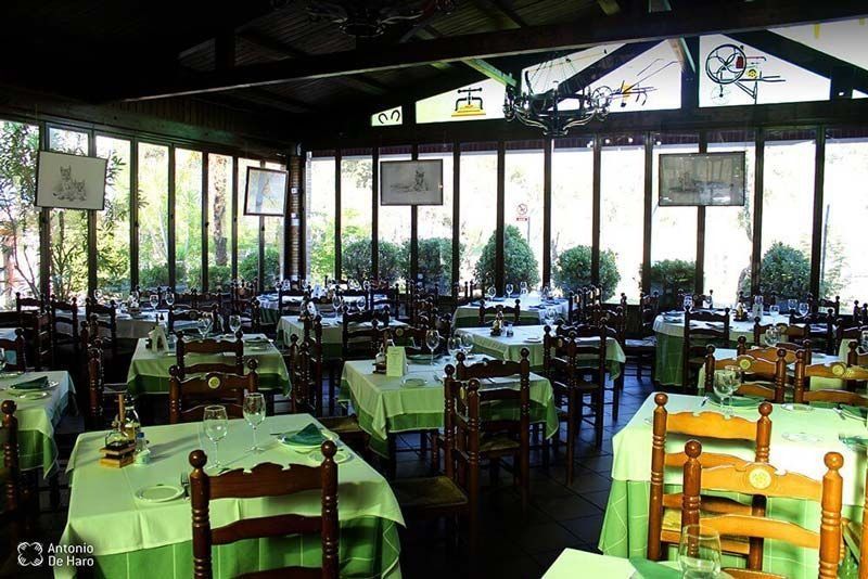Restaurante con mesas y grandes ventanales